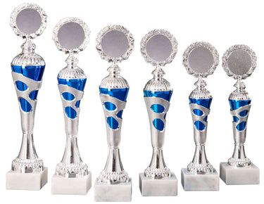 Sechs silberne und blaue Pokale Ahlen 6-er Pokalserie 255 mm – 334 mm PK754680-6-E50 in unterschiedlichen Höhen mit runden Plaketten auf weißem Sockel, im exklusiven Design und in zwei Reihen angeordnet.